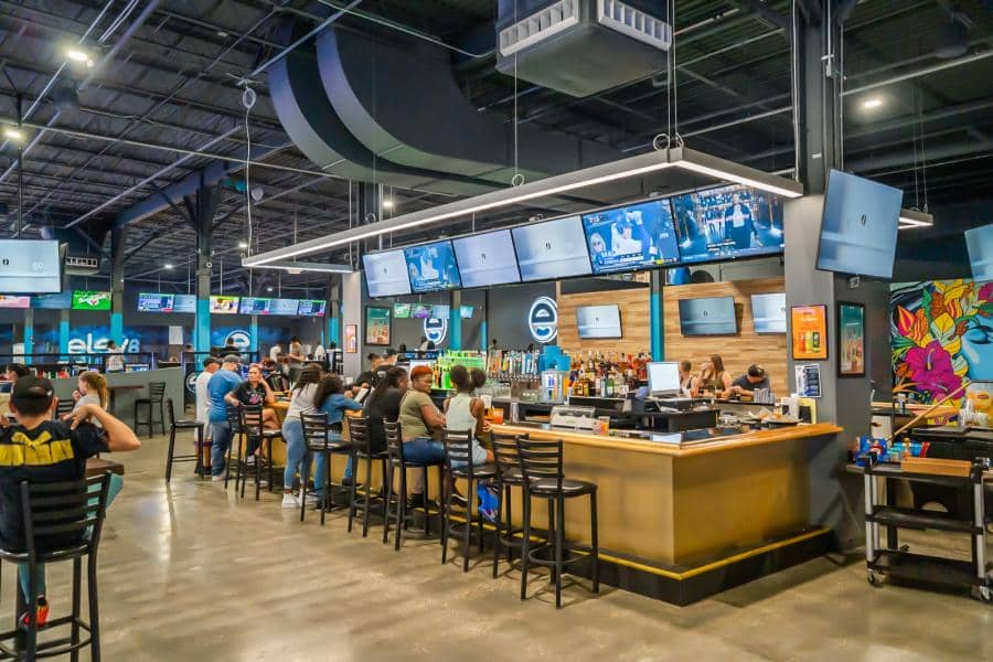 Overview of the bar and restaurant seating area inside Elev8, a family entertainment center (FEC) located inside a shopping mall